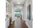 Bright hallway featuring hardwood floors, white cabinetry, modern light fixture, and views to the living room and waterfront at 105 Cordova Ne Blvd, St Petersburg, FL 33704