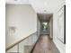 Upstairs hallway with hardwood floors, glass railings, recessed lights, and modern art hanging on the wall at 105 Cordova Ne Blvd, St Petersburg, FL 33704