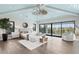 Spacious main bedroom with blue vaulted ceiling, waterfront views, sitting area, and a decorative ceiling fan at 105 Cordova Ne Blvd, St Petersburg, FL 33704
