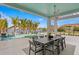 Covered outdoor dining area with a large table, overlooking the pool and waterfront at 105 Cordova Ne Blvd, St Petersburg, FL 33704