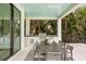 Covered outdoor kitchen and dining area with a built-in grill, sink, and dining table at 105 Cordova Ne Blvd, St Petersburg, FL 33704