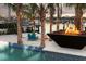 Luxury backyard featuring a pool, a waterfront view, a fire pit, and tropical landscaping at 105 Cordova Ne Blvd, St Petersburg, FL 33704