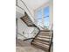 Elegant staircase with wood treads, glass railings, and large windows offering plenty of natural light at 105 Cordova Ne Blvd, St Petersburg, FL 33704