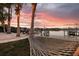 Relaxing waterfront view with a hammock, palm trees, and a beautiful sunset backdrop at 105 Cordova Ne Blvd, St Petersburg, FL 33704