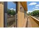 Balcony view with wood railing, exterior light fixture, and sunny exposure at 5325 Bradbury Ct, Tampa, FL 33624