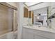 Bathroom showcasing a vanity, mirror, a shower-tub combo and louvered closet doors at 5325 Bradbury Ct, Tampa, FL 33624