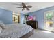 Bright bedroom with a ceiling fan, a dresser with a TV, and access to a private balcony at 5325 Bradbury Ct, Tampa, FL 33624