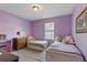 Bright bedroom with two twin beds, a dresser, and a large window for natural light at 5325 Bradbury Ct, Tampa, FL 33624