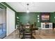 Spacious dining room with wood table and chairs, modern lighting, and green accent walls at 5325 Bradbury Ct, Tampa, FL 33624