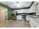 Modern kitchen with white cabinets, stainless steel appliances, granite countertops, and green walls at 5325 Bradbury Ct, Tampa, FL 33624