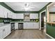 Bright kitchen featuring white cabinets, stainless steel appliances, and contrasting green walls at 5325 Bradbury Ct, Tampa, FL 33624