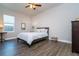 A well-lit bedroom with a ceiling fan, wood floors, and a comfortable bed with side tables at 3604 W Paxton Ave, Tampa, FL 33611