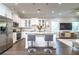 Modern kitchen with white cabinets, stainless steel appliances, and a kitchen island with bar stool seating at 3604 W Paxton Ave, Tampa, FL 33611