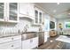 Kitchen area with stainless steel appliances, white cabinets, tile backsplash and granite countertops at 3604 W Paxton Ave, Tampa, FL 33611