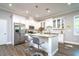 Bright kitchen featuring white cabinetry, granite countertops, stainless steel appliances, and a kitchen island at 3604 W Paxton Ave, Tampa, FL 33611