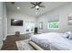 The main bedroom features a ceiling fan, wood floors, television and a glass doors to the outside at 3604 W Paxton Ave, Tampa, FL 33611