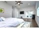 The main bedroom features a ceiling fan, wood floors, television and a glass doors to the outside at 3604 W Paxton Ave, Tampa, FL 33611