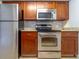 Stainless steel appliances and wood cabinets in kitchen at 4883 W Mcelroy Ave # G211, Tampa, FL 33611