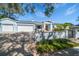 Light blue three-car garage home with landscaped yard at 316 Jasmine Way, Clearwater, FL 33756