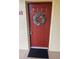 Welcoming red front door featuring a decorative wreath and unit number 722 at 2690 Coral Landings Blvd # 722, Palm Harbor, FL 34684