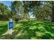 Community pet walk area with green grass, mature trees, and benches for residents to enjoy at 2690 Coral Landings Blvd # 722, Palm Harbor, FL 34684