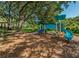 Community playground with various slides and structures for play, set amongst mature shade trees at 2690 Coral Landings Blvd # 722, Palm Harbor, FL 34684