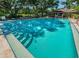 Inviting community pool surrounded by lush landscaping, offering a perfect setting for relaxation and recreation at 2690 Coral Landings Blvd # 722, Palm Harbor, FL 34684