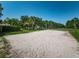 Sand volleyball court offers residents an outdoor recreational amenity with lush landscaping around at 2690 Coral Landings Blvd # 722, Palm Harbor, FL 34684