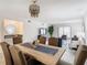 Elegant dining area with a long wooden table and modern chandelier at 3713 Champagne Dr # 115, Tampa, FL 33618