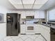 Modern kitchen featuring black refrigerator and white cabinetry at 3713 Champagne Dr # 115, Tampa, FL 33618