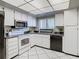 Bright kitchen with white cabinets, stainless steel appliances, and tile flooring at 3713 Champagne Dr # 115, Tampa, FL 33618