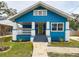 Charming blue home featuring a cozy front porch and a colorful green door at 5205 N 9Th St, Tampa, FL 33603