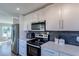 Modern kitchen featuring white cabinets, stainless steel appliances and gray backsplash at 9322 88Th Way, Seminole, FL 33777