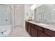 Elegant bathroom with double vanity, granite countertops, and a large shower at 10309 Malvasia Ave, Riverview, FL 33578