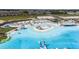 Aerial view of the lagoon with a sandy beach, cabanas, and water activities at 31803 Cardinal Yard Dr, San Antonio, FL 33576