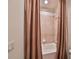 Bathroom with tub and shower, and brown curtains at 805 Seminole Sky Dr, Ruskin, FL 33570