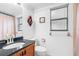 Bright bathroom featuring a wood vanity, black countertop, and decorative wall art at 1104 Kingfish Pl, Apollo Beach, FL 33572