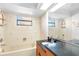 Bathroom featuring a granite countertop, soaking tub, vanity mirror and floral-themed wallpaper at 1104 Kingfish Pl, Apollo Beach, FL 33572