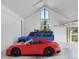 Spacious garage featuring high ceilings, a modern red sports car, and a blue SUV at 1104 Kingfish Pl, Apollo Beach, FL 33572