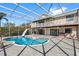 Pool with screen enclosure, slide, and view of home and balconies at 1104 Kingfish Pl, Apollo Beach, FL 33572