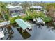 Waterfront home featuring a boat dock, boat lift, screened-in pool, and lush landscaping at 1104 Kingfish Pl, Apollo Beach, FL 33572