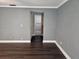 View of a living room with gray walls and wood-look flooring, showing access to bathroom at 11933 72Nd Ave, Seminole, FL 33772