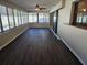 Bright sunroom with dark laminate flooring and multiple windows at 11933 72Nd Ave, Seminole, FL 33772