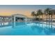 Resort-style pool with palm trees, covered bar and lounging area at sunset at 1209 E Cumberland Ave # 508, Tampa, FL 33602