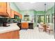 Well-lit kitchen with wooden cabinets, white countertops and flooring, plus eat-in breakfast nook at 270 Pinewinds Blvd, Oldsmar, FL 34677