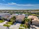 Aerial view of a luxury community featuring lakefront homes with tile roofs and lush landscaping at 30200 Southernwood Ct, Wesley Chapel, FL 33543