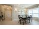 Elegant dining room with a wood table, six chairs, and a chandelier at 30200 Southernwood Ct, Wesley Chapel, FL 33543