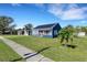 Blue house with solar panels, red door, and green lawn at 1001 57Th N Ave, St Petersburg, FL 33703