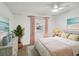 Cozy bedroom with pink bedding and coastal-themed art at 1524 Lakeview Rd # 103, Clearwater, FL 33756