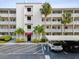 Condo building with parking and tropical landscaping at 1524 Lakeview Rd # 103, Clearwater, FL 33756